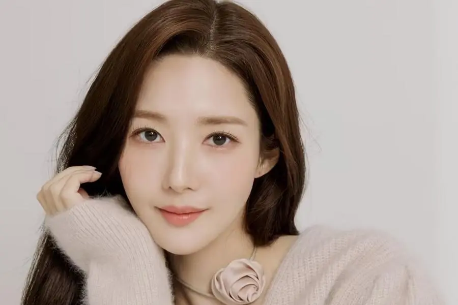 Park Min Young souriante lors d’un événement promotionnel, vêtue d’une tenue élégante, incarnant son nouveau rôle audacieux dans The Confidence Man KR.